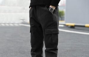 Shopping Boys Pants Online? Here’s How to Get the Best Deals Boy in black cargo pants and white sneakers standing on pavement.