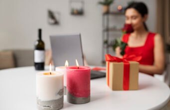 How to Store Soy Candles to Preserve Fragrance and Appearance Lit soy candles with gift box and woman holding rose in background